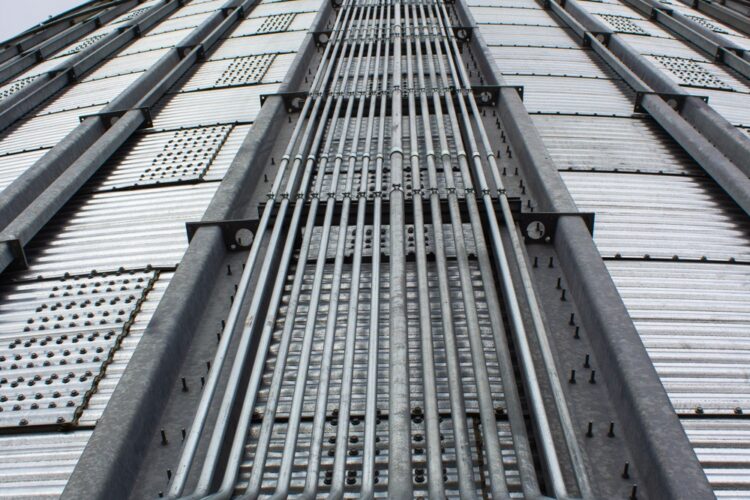 Multiple runs of electrical conduit installed neatly on a concrete silo by Area Energy & Electric Inc.