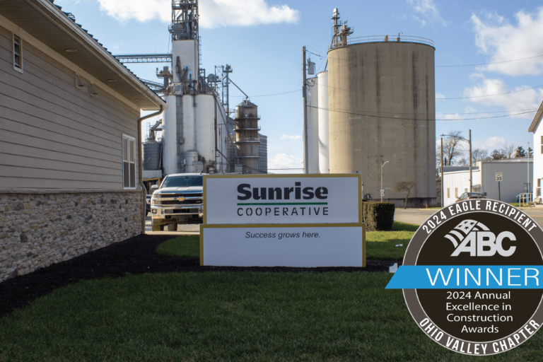 Sunrise Cooperative main office with silos and grain bins in the background. Labeled with ABC EIC Eagle Award winner.